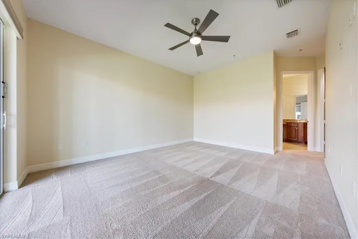 Spare room featuring ceiling fan and light colored carpet