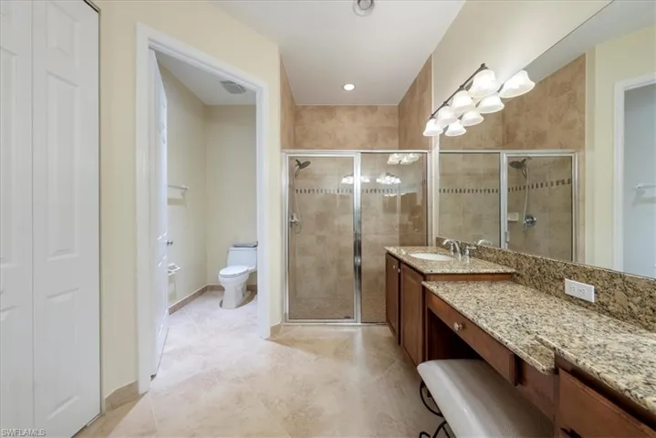 Bathroom with vanity, toilet, and a shower with door