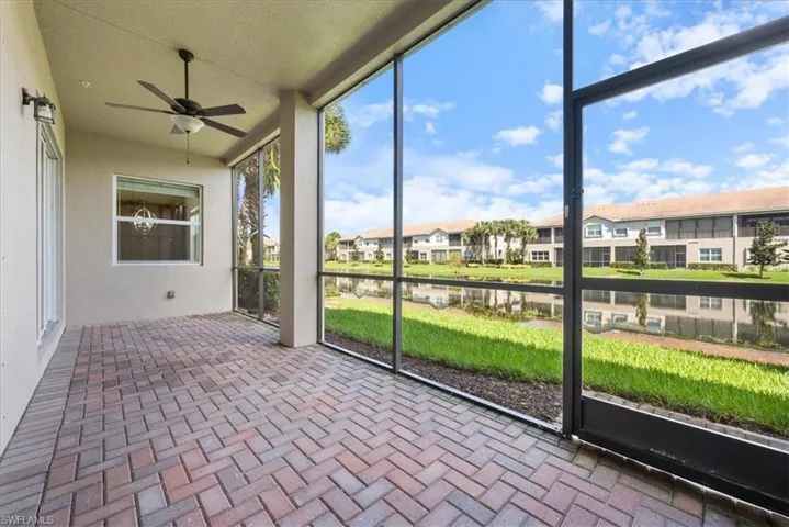 Unfurnished sunroom with ceiling fan and a water view