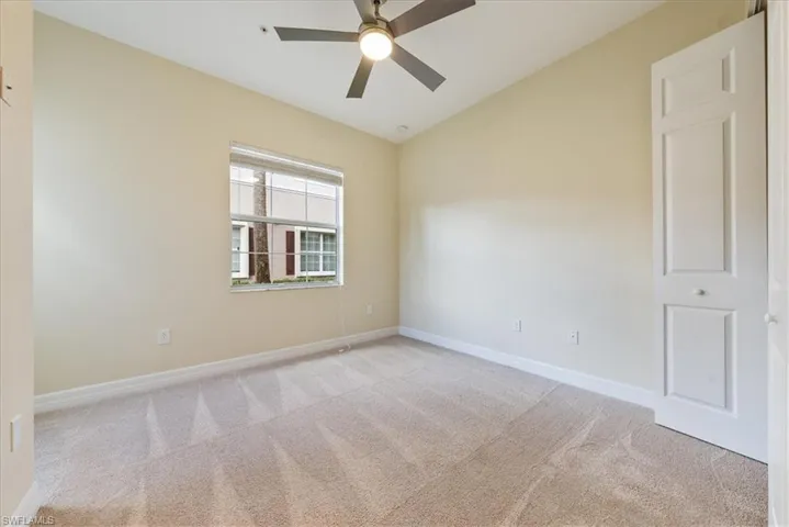 Carpeted spare room with lofted ceiling and ceiling fan