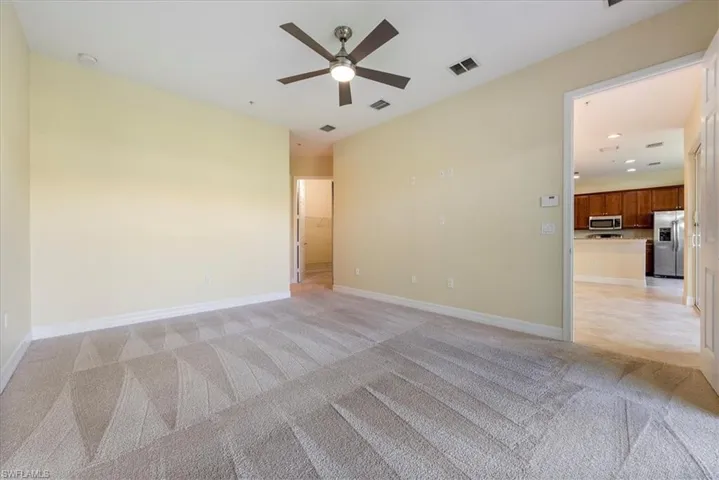 Carpeted spare room with ceiling fan