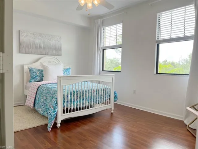 Bedroom with dark wood finished floors and a ceiling fan