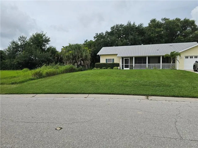 Single story home featuring a garage and a front lawn