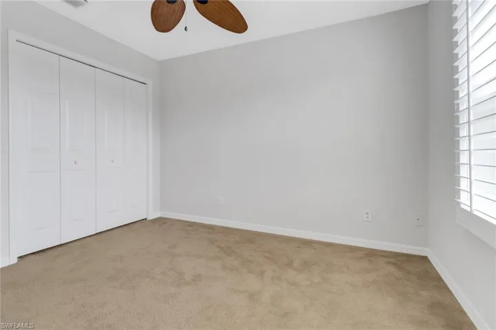 Unfurnished bedroom with carpet floors, visible vents, baseboards, and a closet