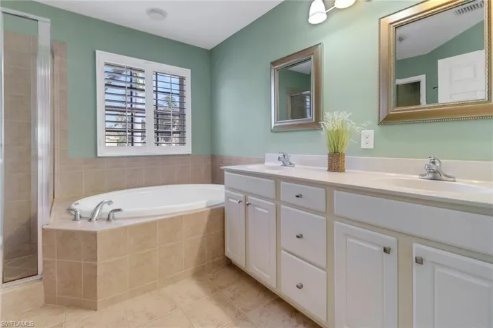 Full bath with a garden tub, a sink, and a shower stall