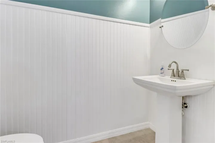 Bathroom featuring wainscoting, a sink, toilet, and tile patterned floors
