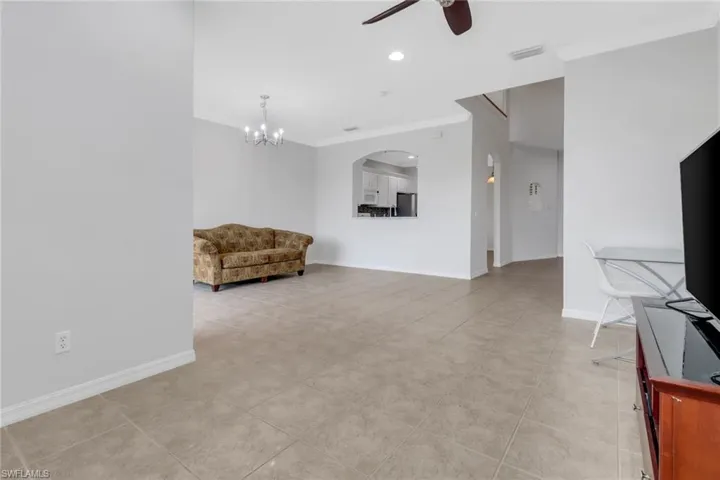Sitting room with recessed lighting, ceiling fan with notable chandelier, visible vents, baseboards, and crown molding