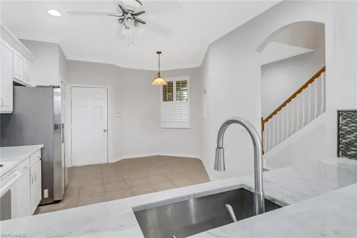 Kitchen featuring ornamental molding, white cabinetry, a sink, and light tile patterned floors