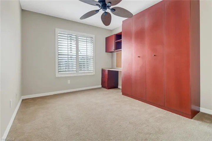 Unfurnished bedroom featuring light carpet, ceiling fan, and baseboards