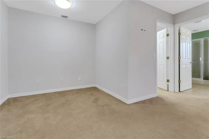 Unfurnished room with baseboards, visible vents, and light colored carpet