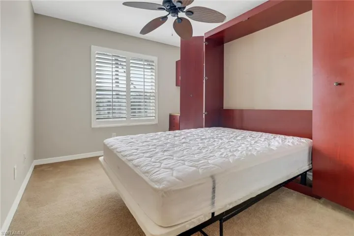 Bedroom featuring ceiling fan, carpet floors, and baseboards