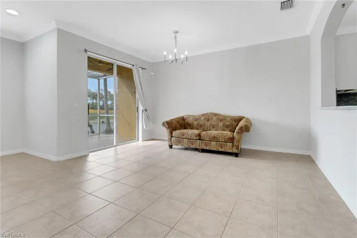 Sitting room with ornamental molding, tile patterned flooring, visible vents, and baseboards