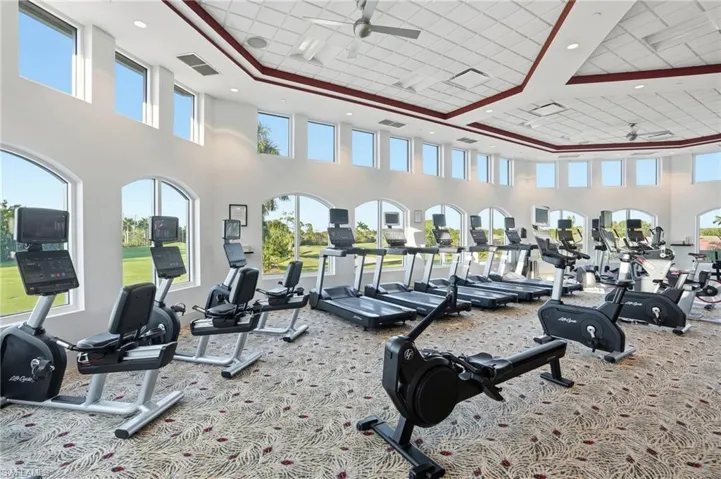 Workout area with ceiling fan and a high ceiling