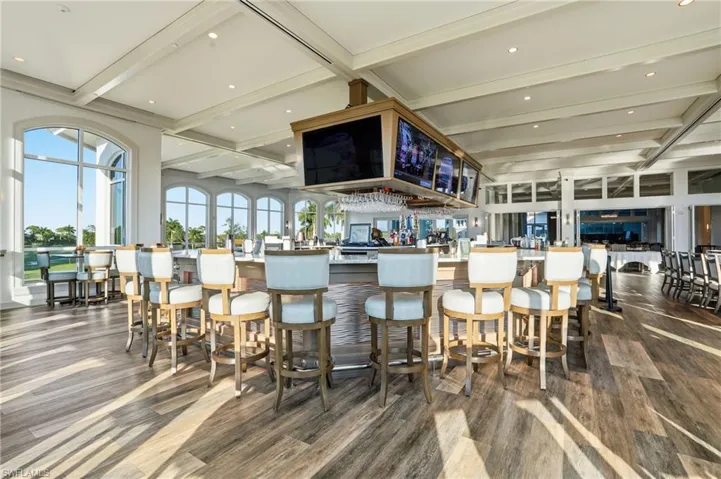 Bar area with beam ceiling, light stone countertops, coffered ceiling, and recessed lighting