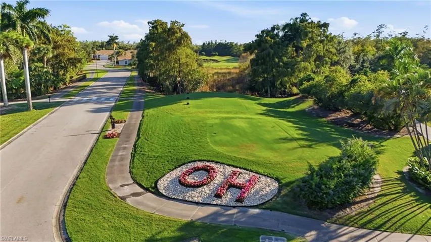 View of property's community with a lawn, view of golf course, and view of wooded area