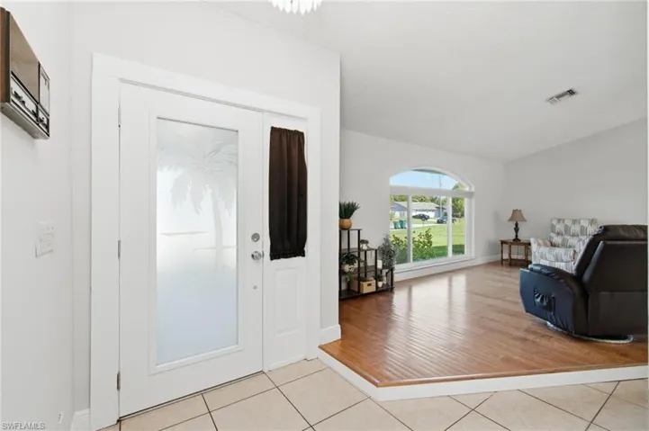 Entryway featuring door with frosted glass inserts and palm tree etching