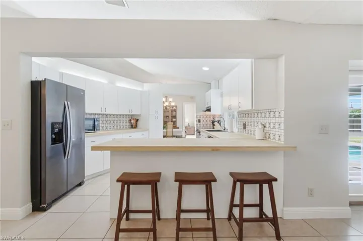 Kitchen pass-through featuring an extended countertop and integrated breakfast bar