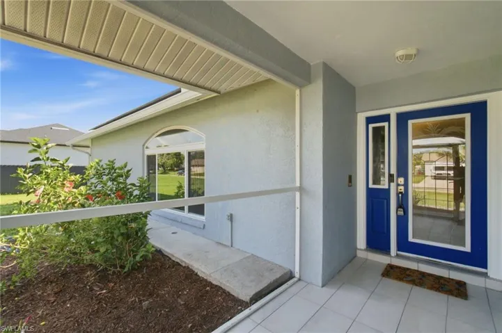 Front entrance featuring a vibrant blue double door with glass inserts and a coordinating sidelight