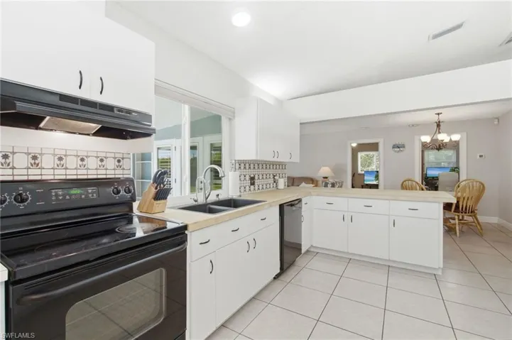 Kitchen featuring white cabinetry, light countertops, and tile flooring