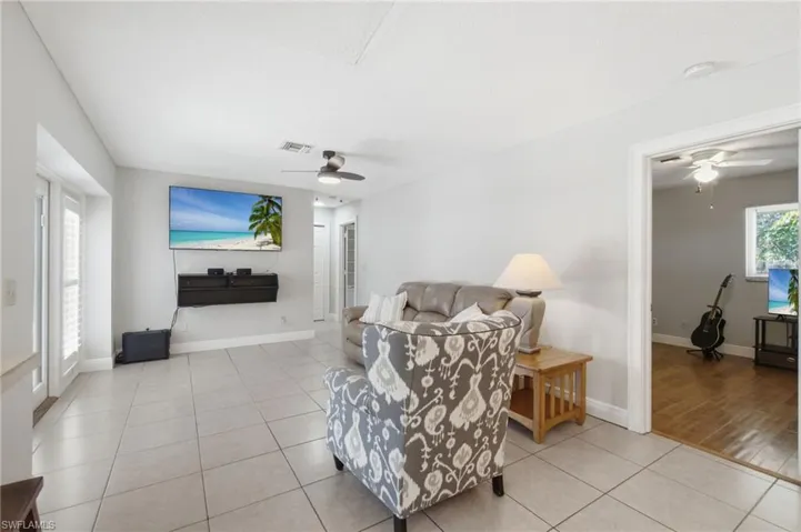 Spacious living area featuring light-toned tile flooring throughout