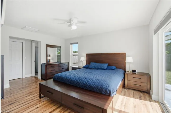 Spacious bedroom featuring wood-finish flooring, white walls, and a ceiling fan