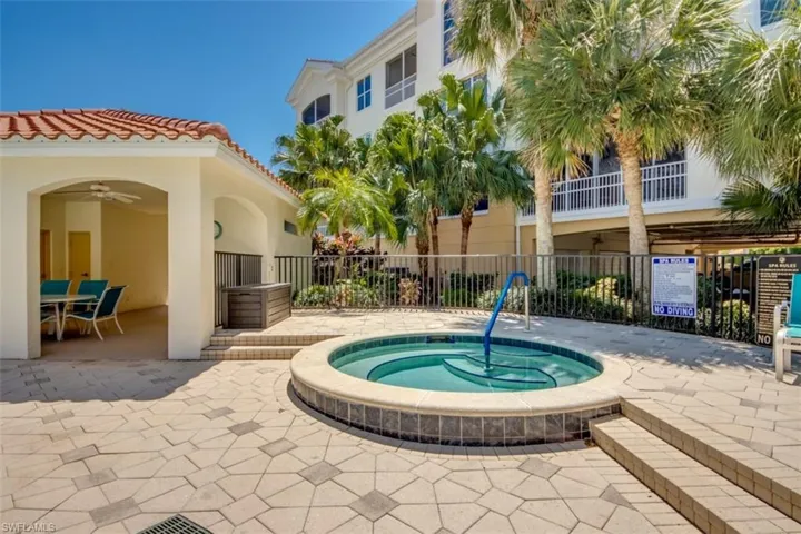 View of pool featuring a ceiling fan, a patio area, a hot tub, and fence