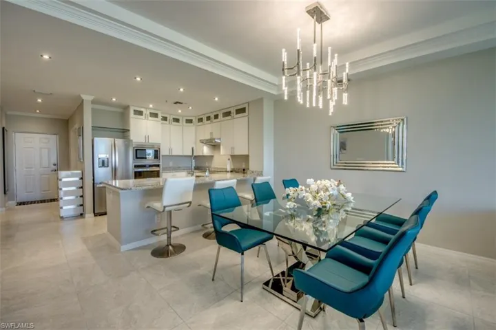 Dining area with a chandelier, crown molding, baseboards, and recessed lighting