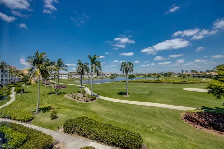 View of community featuring a water view, view of golf course, and a lawn