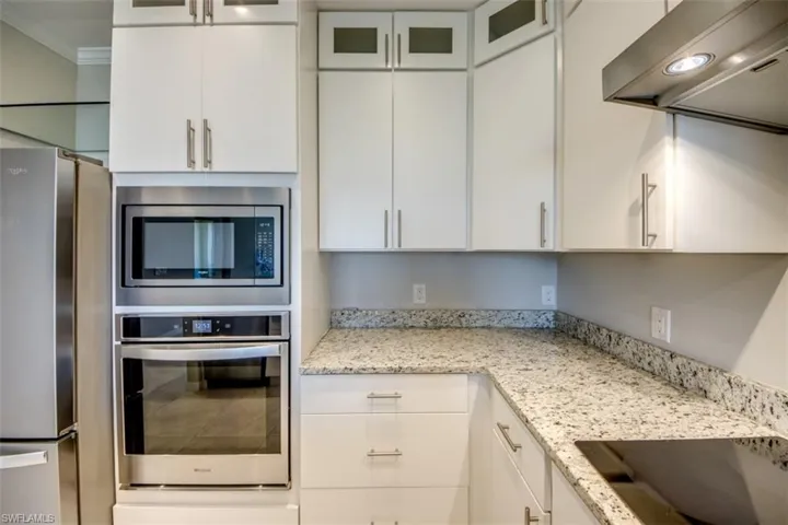 Kitchen featuring white cabinets, appliances with stainless steel finishes, and extractor fan