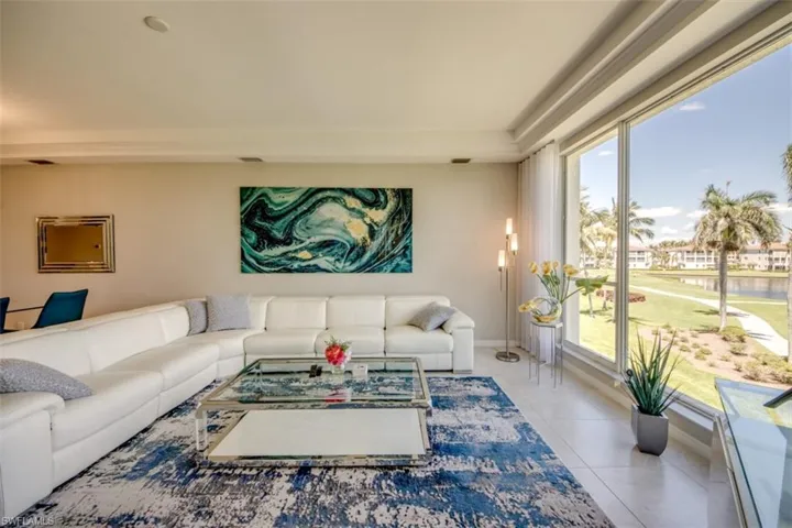 Living area featuring a water view, tile patterned flooring, and baseboards