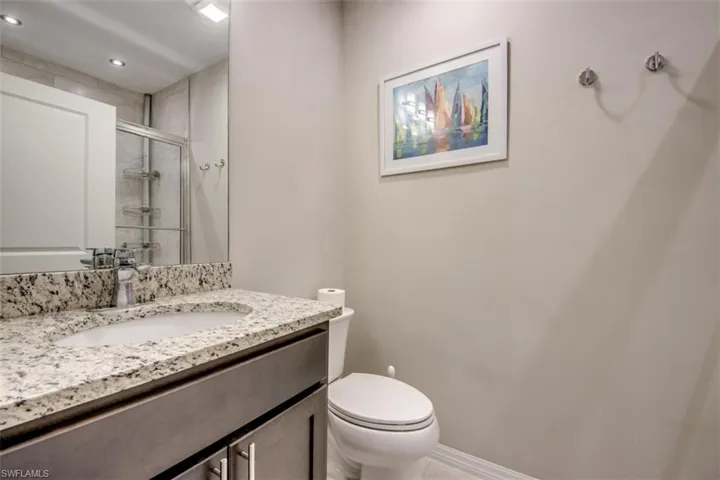 Bathroom featuring toilet, a shower stall, vanity, and recessed lighting
