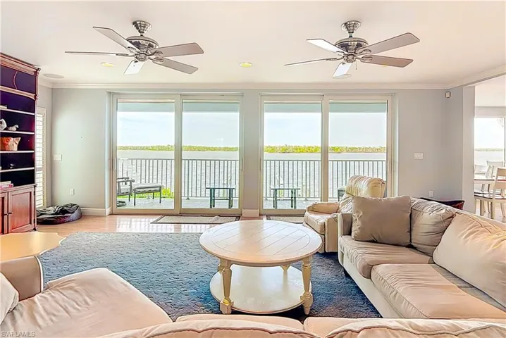 Living area featuring plenty of natural light, ornamental molding, ceiling fan, and wood finished floors