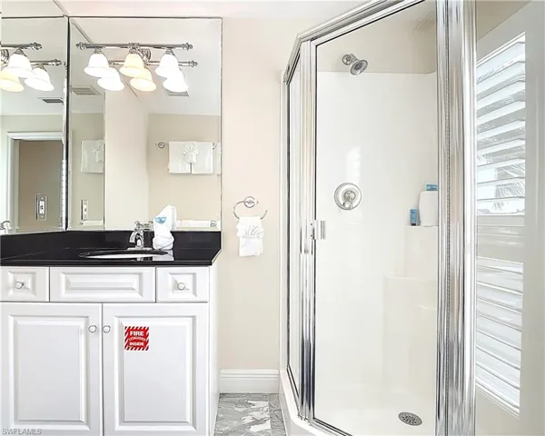 Bathroom featuring vanity and a shower stall