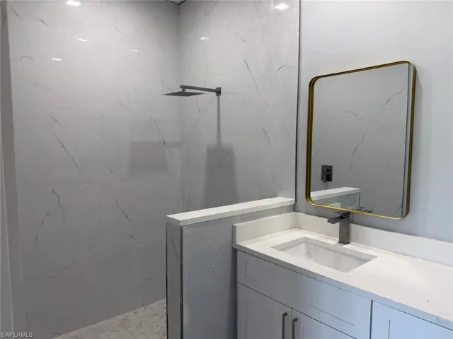 Full bathroom with vanity and a marble finish shower