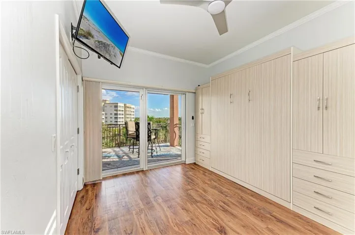 Unfurnished bedroom with a closet, light wood finished floors, access to exterior, a ceiling fan, and crown molding