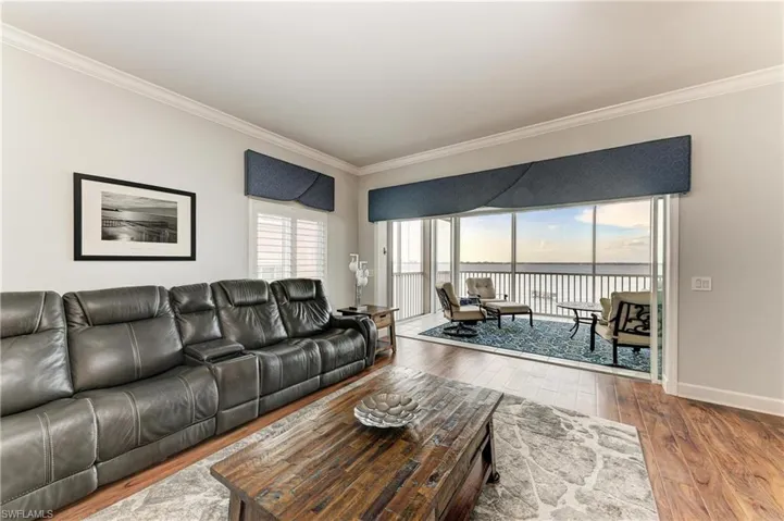 Living area featuring light wood-style floors, ornamental molding, and a water view