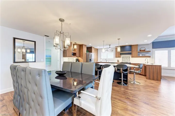 Dining room with light wood-style flooring, plenty of natural light, and suspended lighting