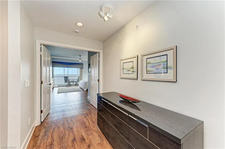 Hall with dark wood-style floors and baseboards