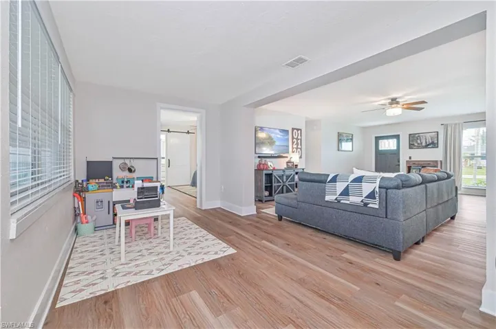 Living room with ceiling fan and light hardwood / wood-style flooring