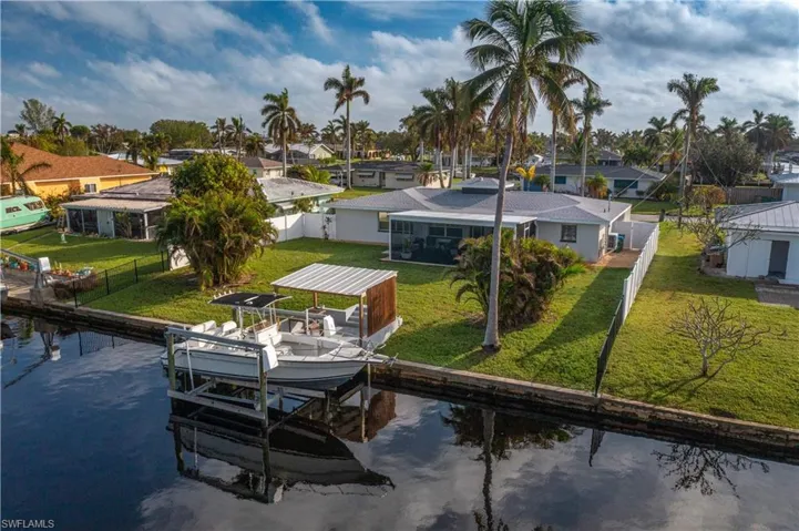 Dock area featuring a lawn and a canal view