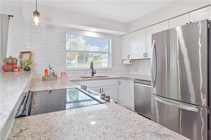 Kitchen featuring white cabinetry, sink, appliances with stainless steel finishes, and tasteful backsplash