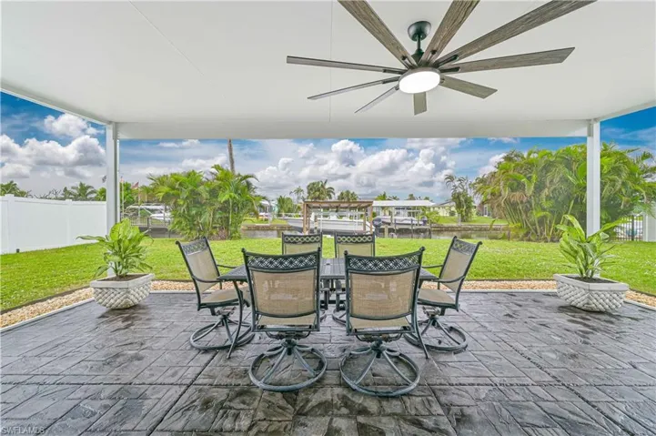 View of patio with ceiling fan looking out to dock and canal