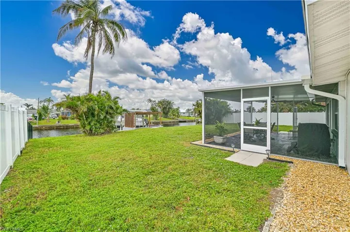 View of yard featuring a water view and a screened lanai