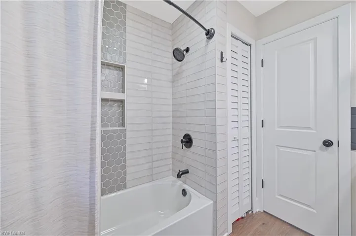 Bathroom featuring shower / tub combo with curtain and hardwood / wood-style flooring