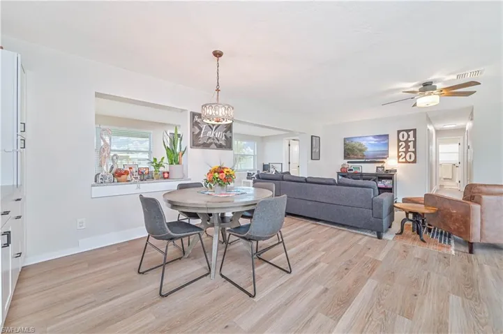 Dining room featuring ceiling fan with notable chandelier and light hardwood / wood-style flooring
