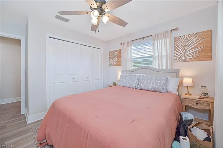 Bedroom with ceiling fan, a closet, and light wood-type flooring