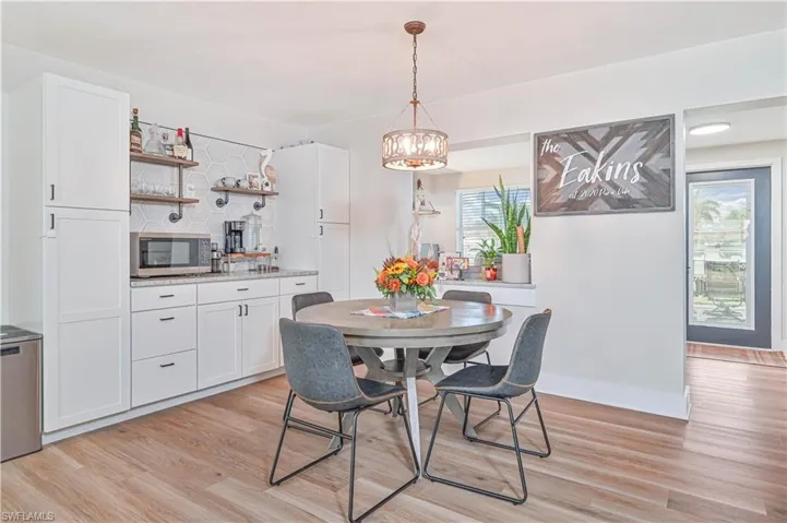 Dining space with a wealth of natural light, an inviting chandelier, and light hardwood / wood-style floors