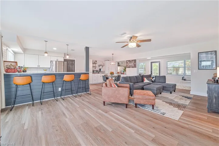 Living room with ceiling fan and light hardwood / wood-style flooring