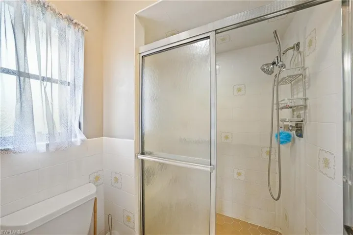 Bathroom featuring a shower stall and plenty of natural light