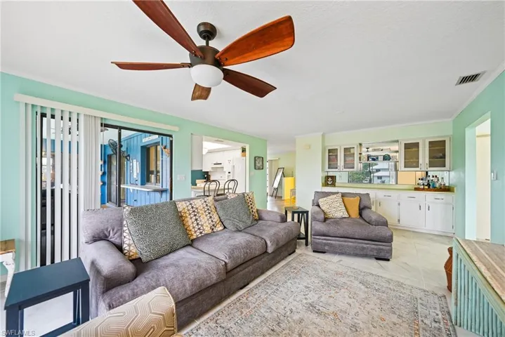 Living room featuring a ceiling fan and ornamental molding
